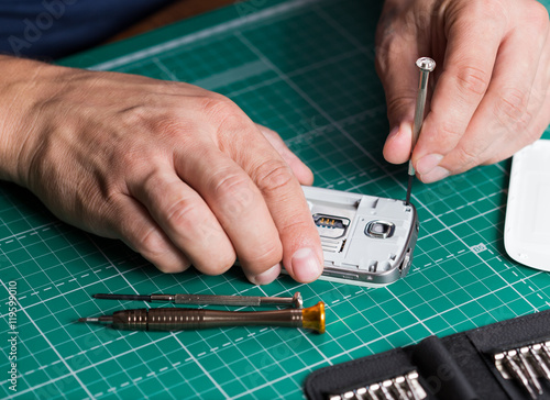 Man repairing broken smartphone, close up photo