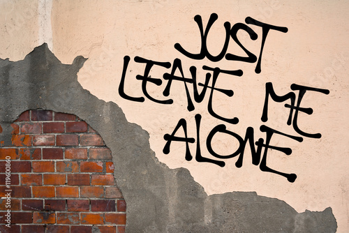 Just Leave Me Alone - Handwritten graffiti sprayed on the wall, anarchist aesthetics - wish to be separated and secluded from other people or reaction to argument and annoying behavior photo