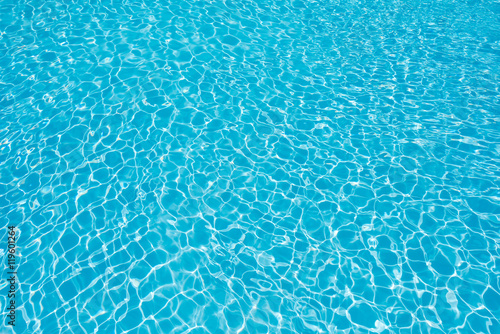 Ripple water surface with sun reflection in swimming pool