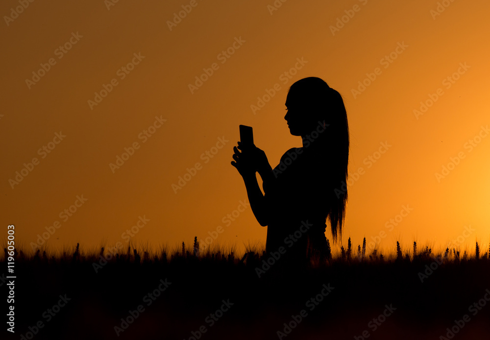 Silhouette of girl with cell phone