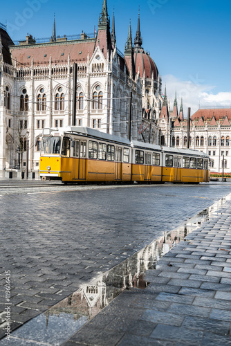 Historical tram passing by Parliament Building in Budapest