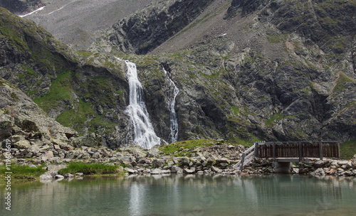 Obraz na płótnie Bergsee mit Wasserfall und Brücke w salonie
