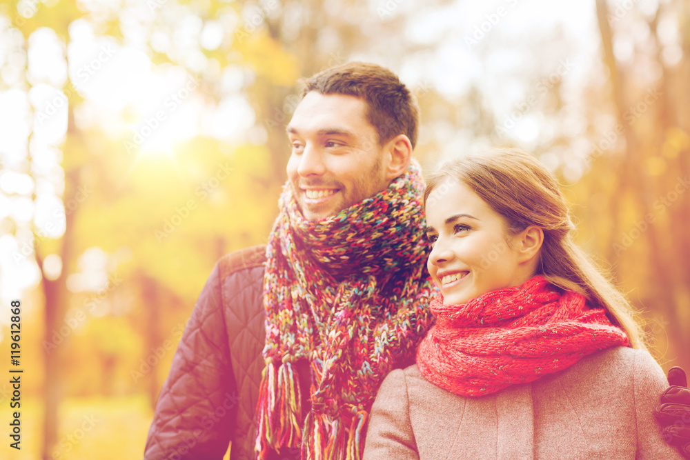 Fototapeta premium smiling couple hugging on bridge in autumn park
