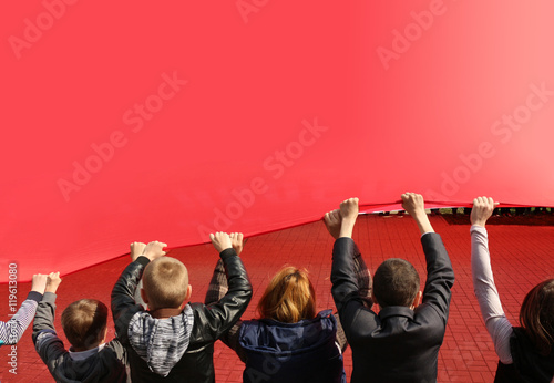 Children hold cloth of red flag