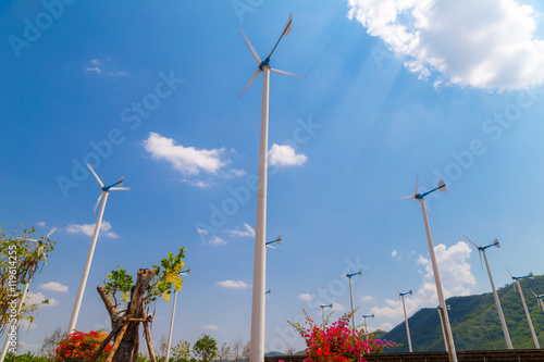 Wind turbine blue sky background agianst mountain photo