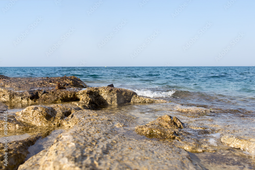 Sea wave splashing over the shore rocks with a high sea spray Sea wave splashing over the shore rocks with a high sea spray