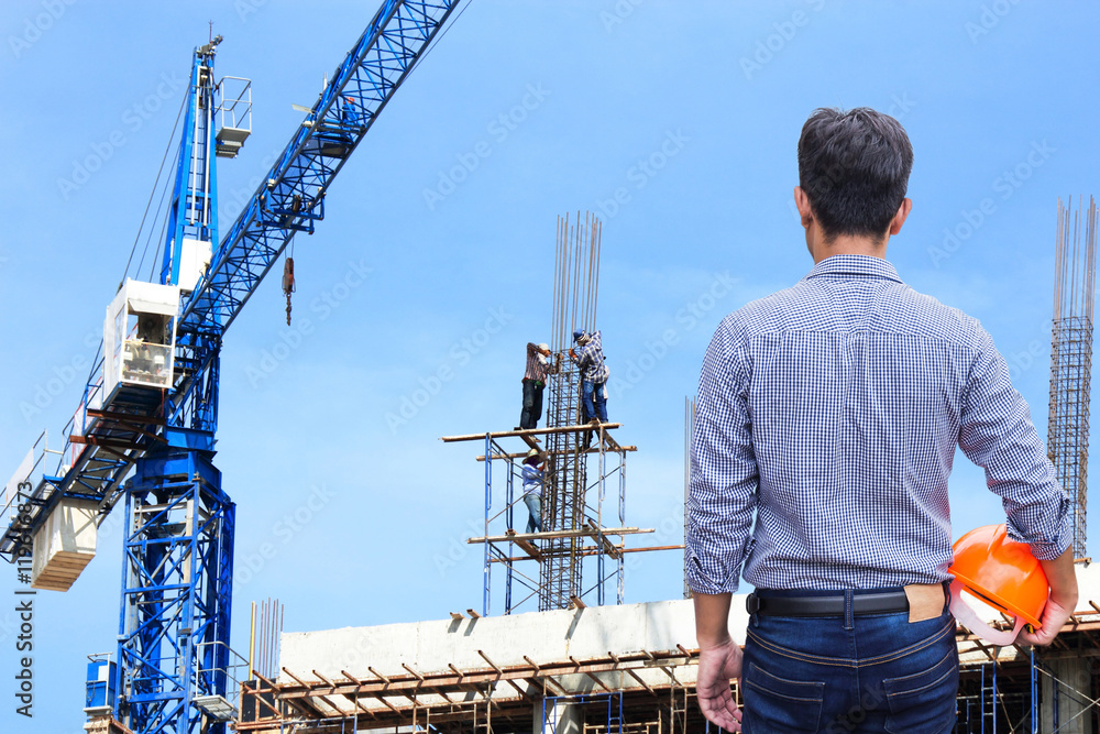 engineer holding yellow safety helmet in building construction site engineer holding yellow safety helmet in building construction site