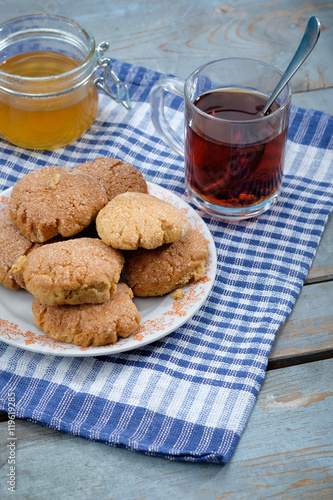 Tea, honey and honey cookies on wooden table