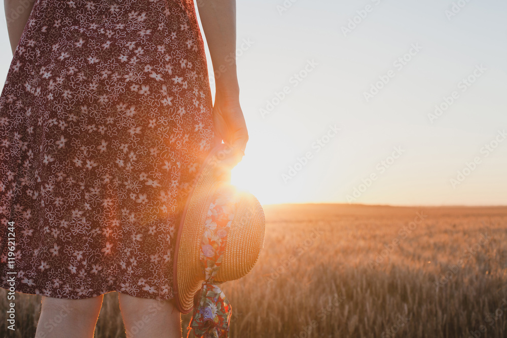 Naklejka premium farewell or waiting concept, summer sunset, woman hand holding hat