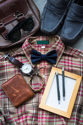 Flat lay, Men's casual outfits background, brown plaid shirt, bow tie, blue shoes, brown bag and accessories