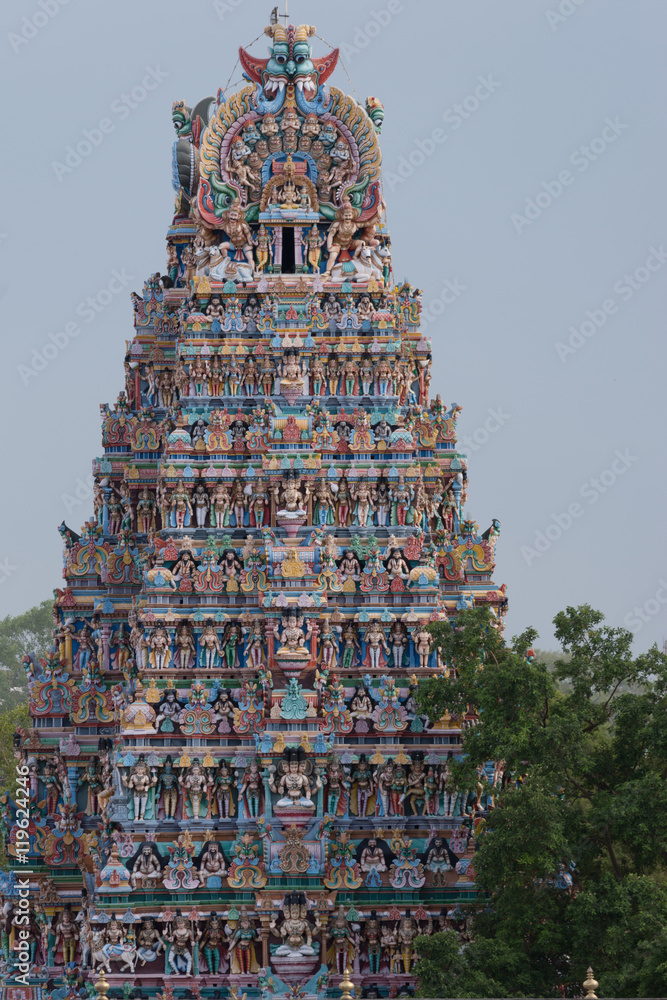 Madurai, India - October 19, 2013: Closeup of one Vimanam of the Meenakshi Temple against bluish skies. Pastel colors and abundance of statues.