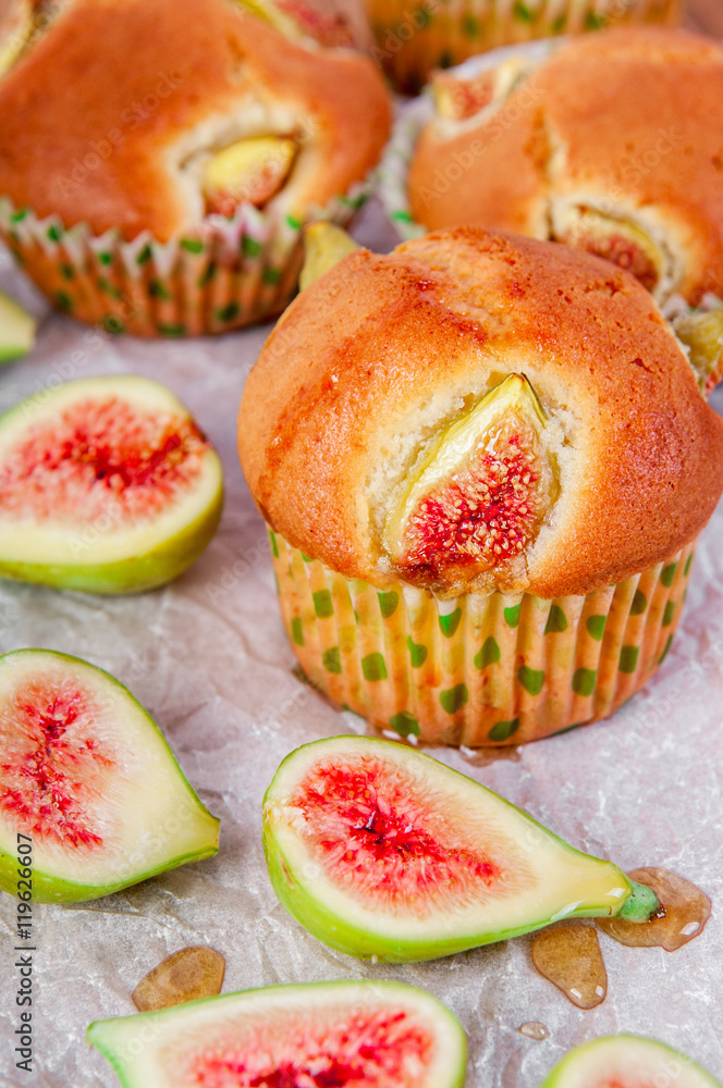 Figs muffins with fresh fruits on baking paper and wooden background