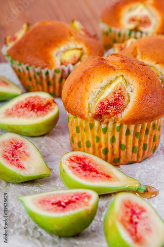 Figs muffins with fresh fruits on baking paper and wooden background