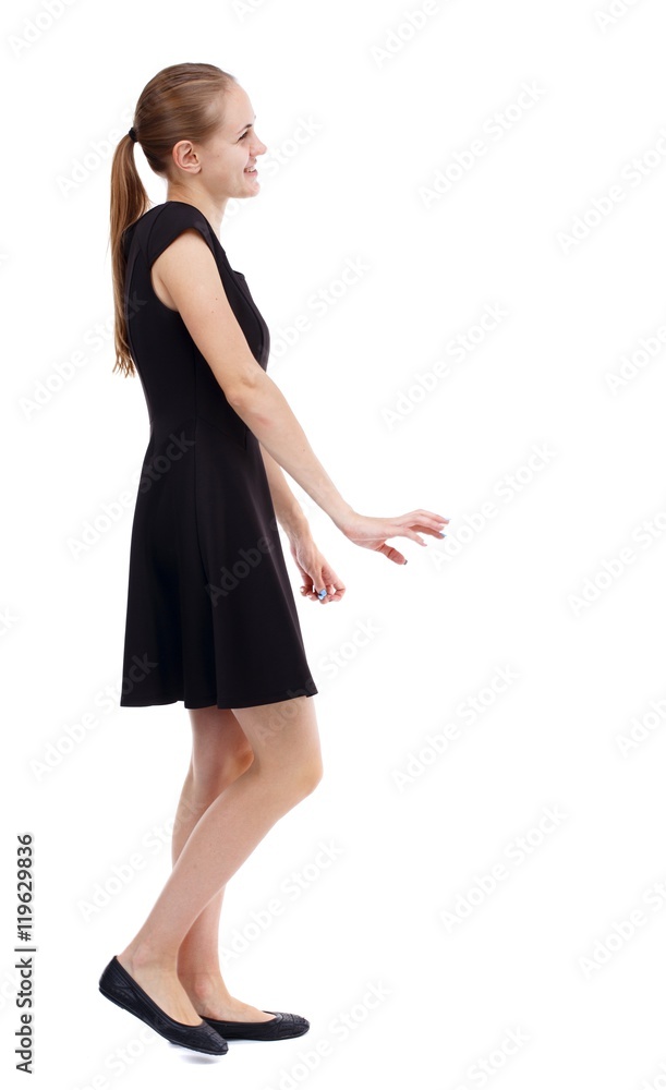 back view of walking woman. Isolated over white background. Blonde in a short black dress is smiling. back view of walking woman. Isolated over white background. Blonde in a short black dress is smiling.