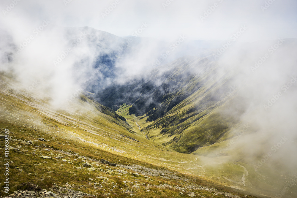 Mountain peaks in the clouds in Fagaras, Carpathian Mountains, Romania