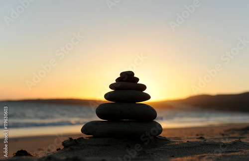 Zen stones on the sand at sunset