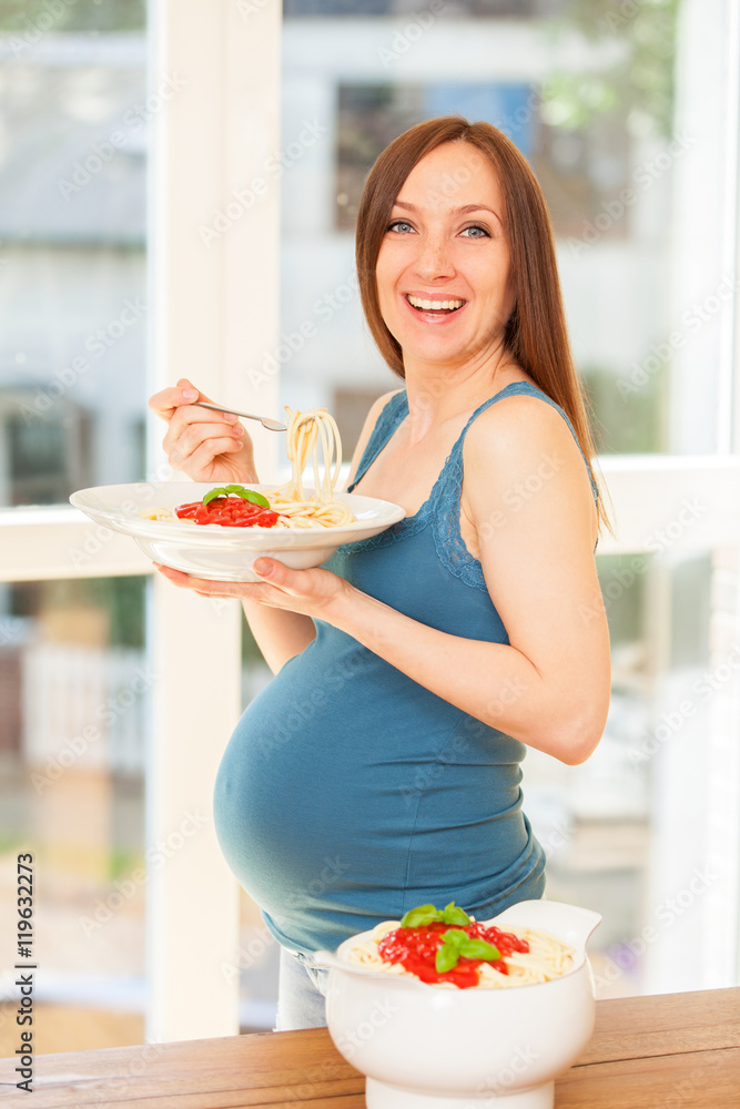 Fotografia do Stock Pregnant woman is eating huge portion of pasta