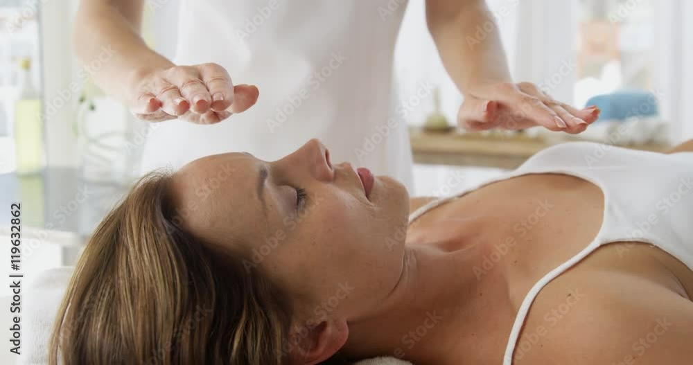 Therapist putting her hands above the patient Therapist putting her hands above the patient