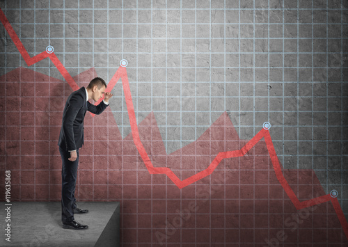 Konstfotografi Businessman shading eyes with his hand looking at falling diagram