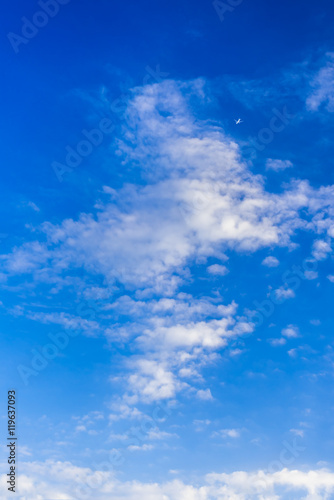 Blue sky background with white clouds and airplane