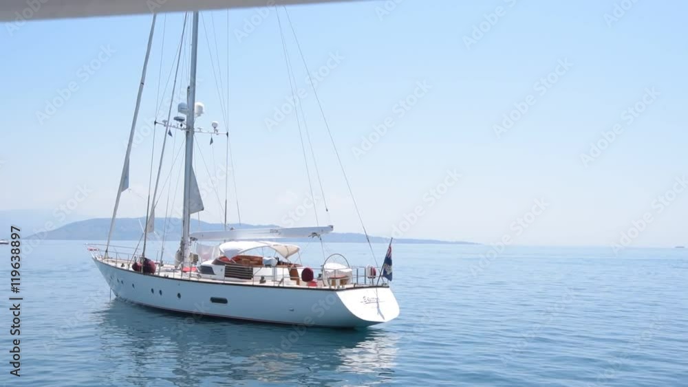 A yacht floats on the calm blue ocean