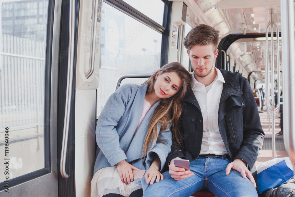 couple in metro, young commuters sitting together couple in metro, young commuters sitting together