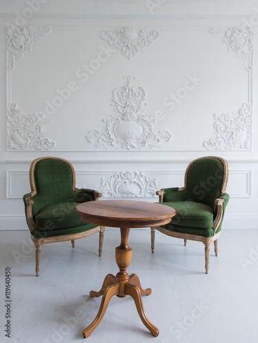 Luxury clean bright white interior with a old antique vintage green chairs over wall design bas-relief stucco mouldings roccoco elements