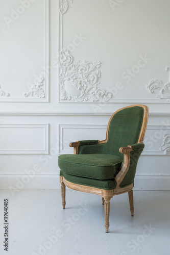 One classic armchair against a white wall and floor. Copy space