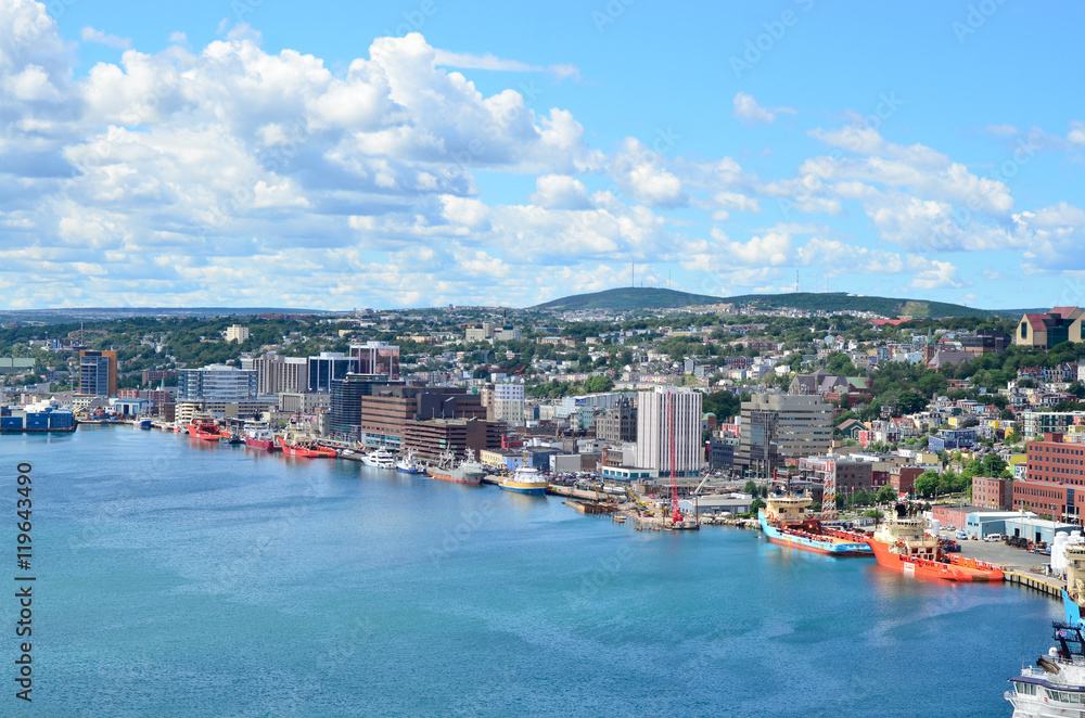 Panoramic views with bight blue summer day sky with puffy clouds over the harbor and city of St. John's Newfoundland, Canada.