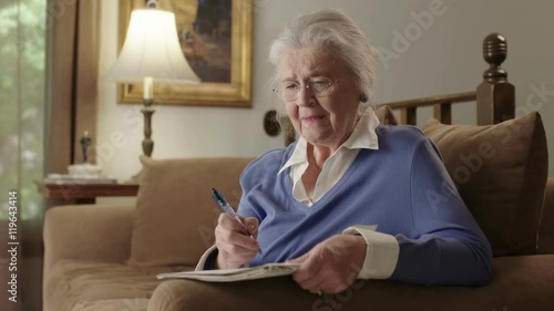 A senior elderly woman on a couch suffers dementia or Alzheimer's and can't remember something. Shot in 4K UHD.