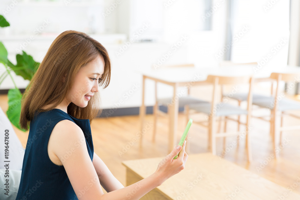 部屋でスマホを見る女性 部屋でスマホを見る女性