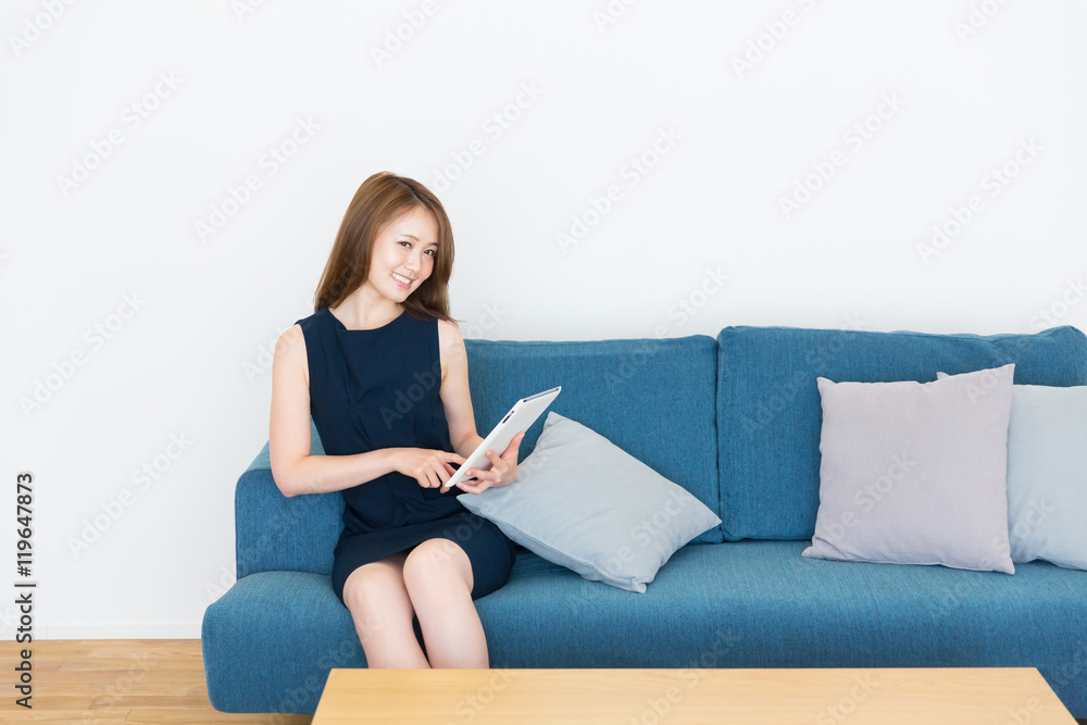 部屋でタブレットを見る女性 部屋でタブレットを見る女性