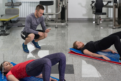 Group Of Smiling People Exercising In The Gym