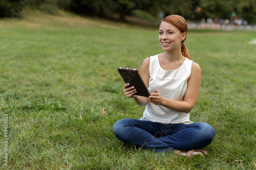 Caucasian woman in city park using tablet computer