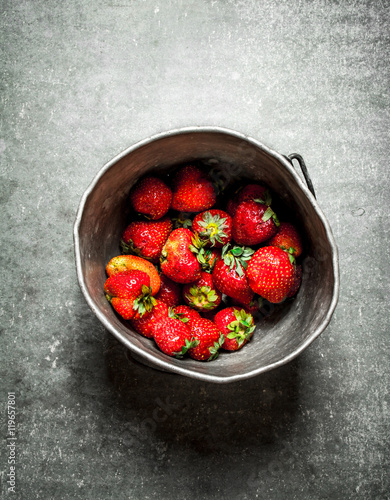 Ripe strawberries in an old pot.