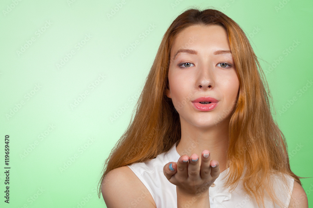 Portrait of a young beautiful brunette girl posing blowing a kiss