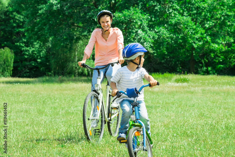 Fototapeta premium Mother And Son Are Cycling In The Park