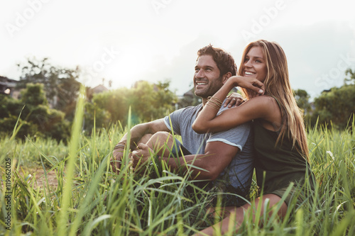 Affectionate young couple sitting on rural grass