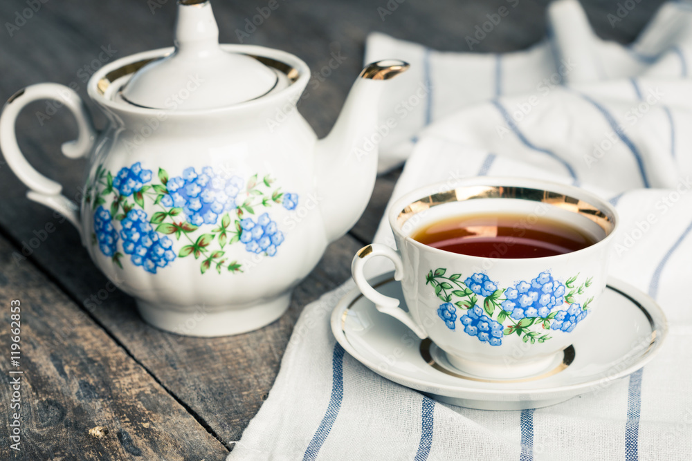 still life with tea cup and tablecloth on wooden table still life with tea cup and tablecloth on wooden table