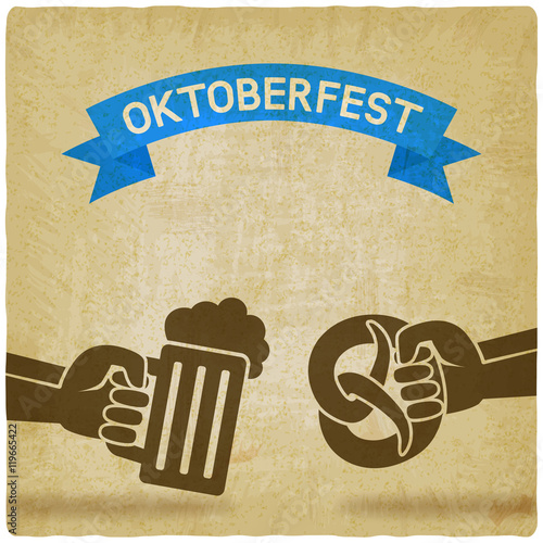 Oktoberfest concept. Hand with beer mug and pretzel old background