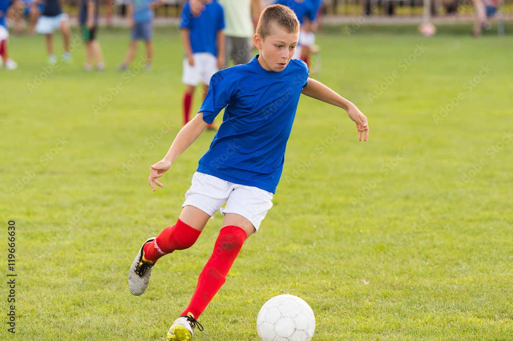 Boys playing football soccer game on sports field Boys playing football soccer game on sports field