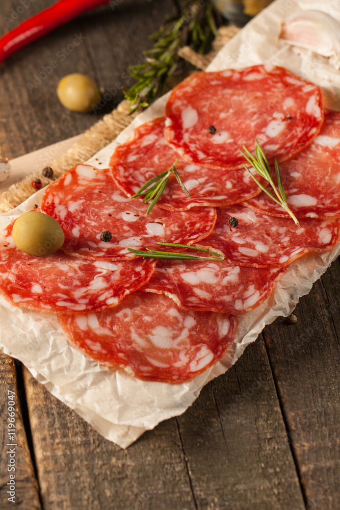 Chorizo sausage and salami, thin cut. spanish salami on the wood background with spices, paprika, pepper. Spicy food. Chili. Chorizo sausage and salami, thin cut. spanish salami on the wood background with spices, paprika, pepper. Spicy food. Chili.