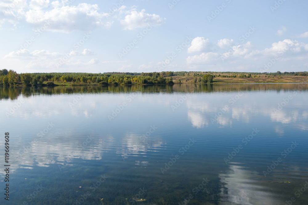 Calm clear lake in the woods. Autumn, september landscape