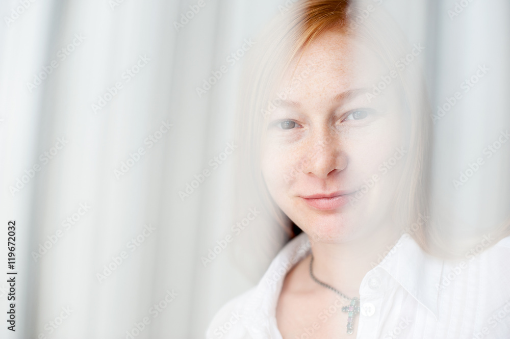 Red-haired woman smiling through white veil Red-haired woman smiling through white veil