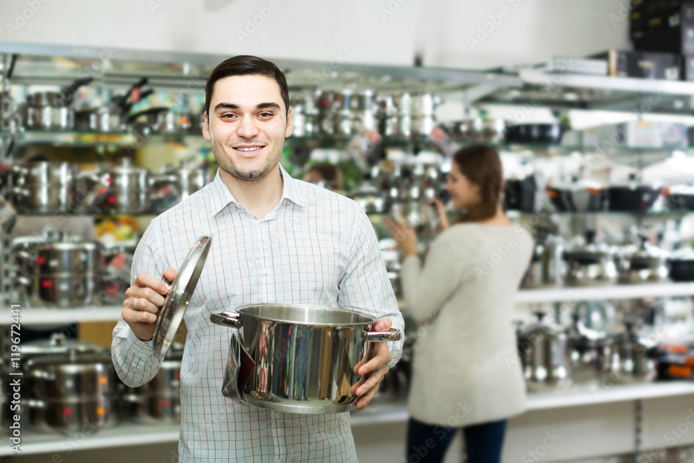 couple chooses pans in shop cookware