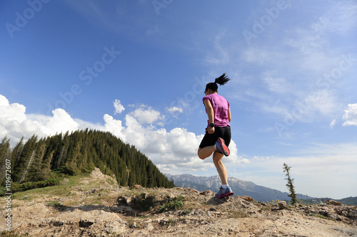 healthy lifestyle woman trail runner running on beautiful mountain peak