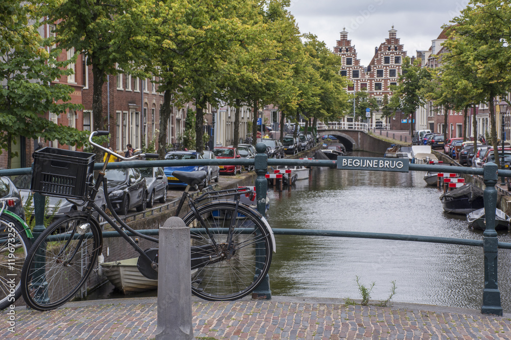 Bike on the bridge near the canal with several dutch houses as background in Haarlem in the Netherlands