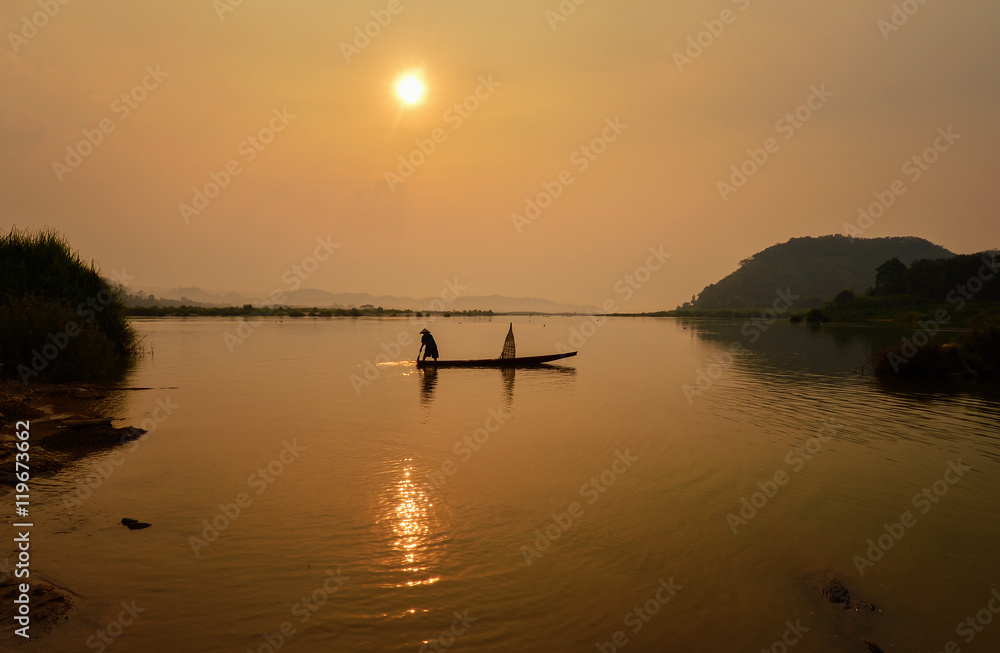 Silluate fisherman and boat in river on during sunrise,Thailand