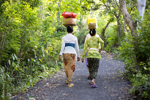 NUSA PENIDA, INDONESIA - AUGUST  13 2016 : Hindu women carry on their heads offerings, August 13. 2016 in - Nusa Penida, Indonesia