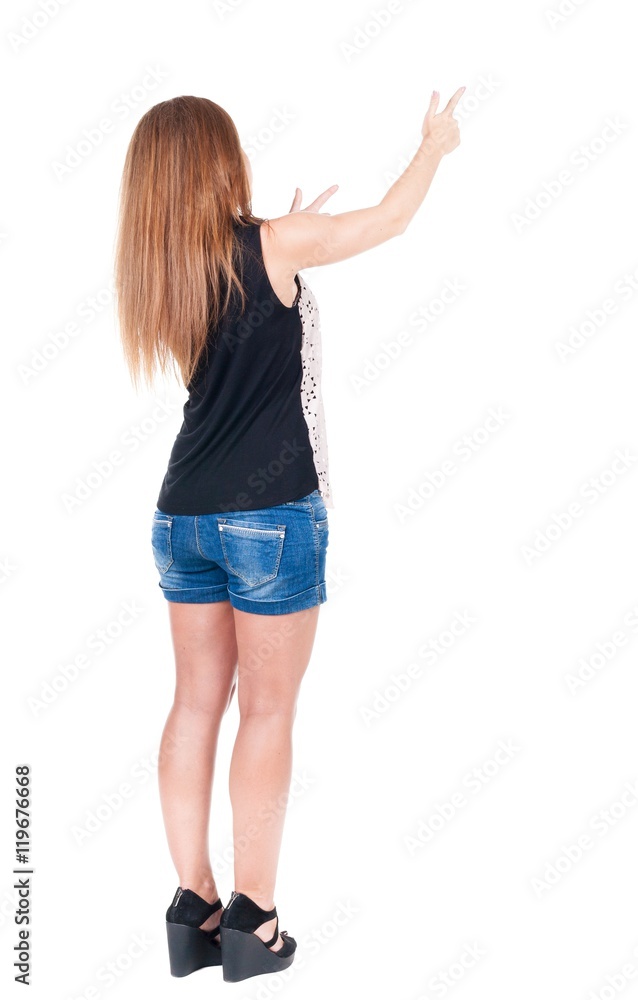 Back view of pointing woman. beautiful redhead girl in shorts. Rear view people collection. backside view of person. Isolated over white background. Back view of pointing woman. beautiful redhead girl in shorts. Rear view people collection. backside view of person. Isolated over white background.
